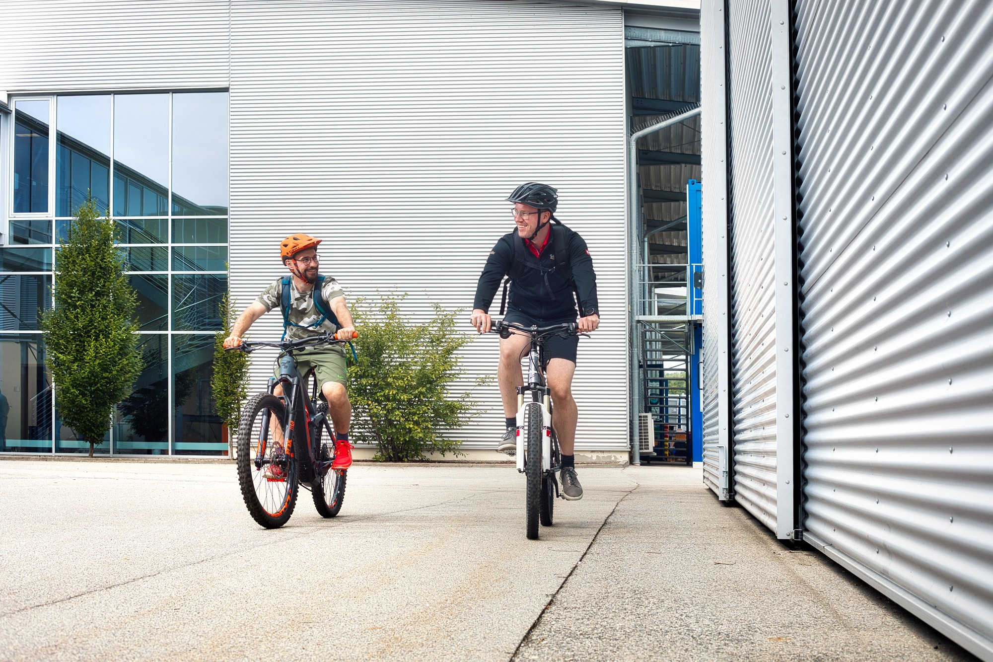 Fahrradleasing - 2 Mitarbeiter kommen mit dem Fahrrad / E-Bike zur Arbeit