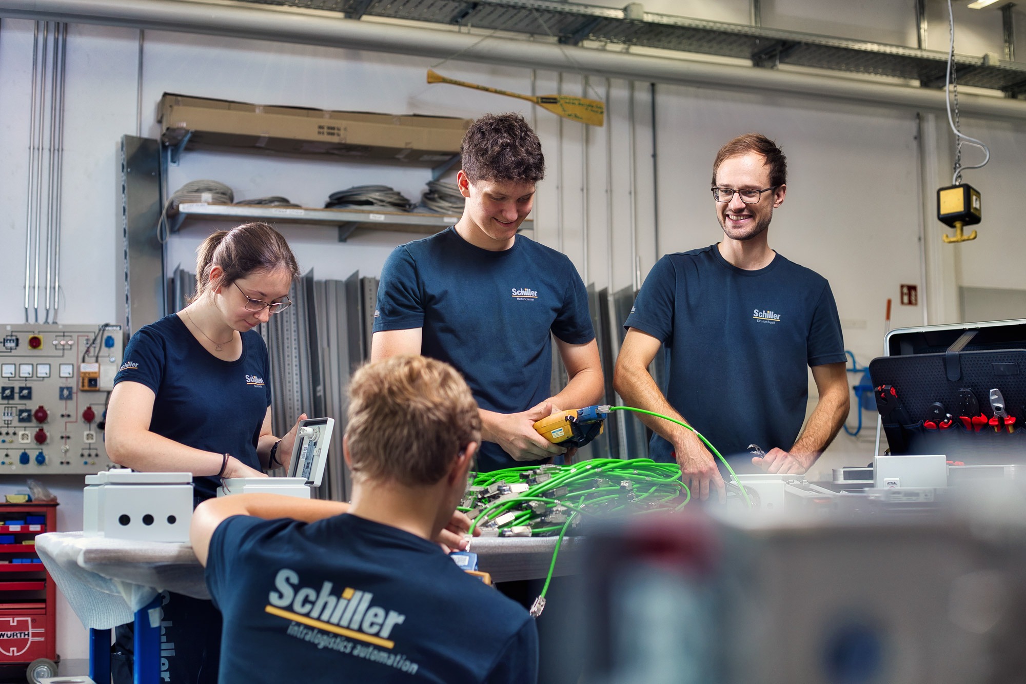 4 Elektroniker für Betriebstechnik arbeiten an Kabel